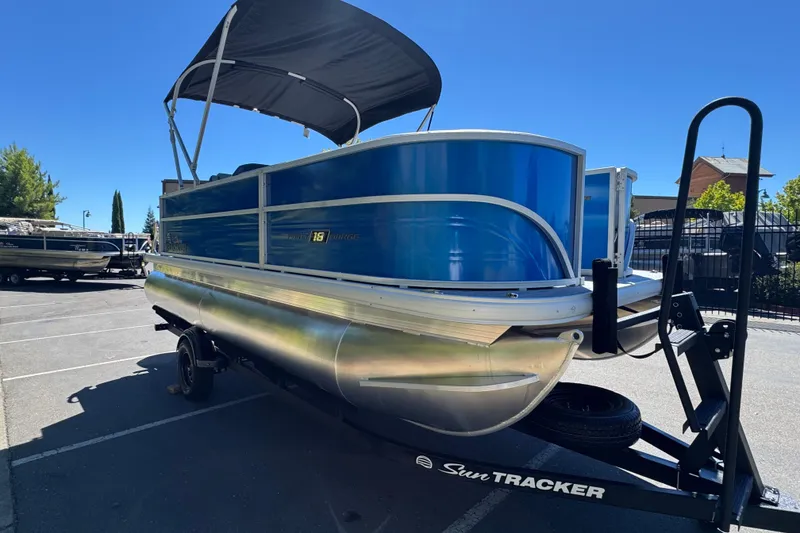 Slide: The Image of 2026 Sun Tracker Party Barge 18 DLX pontoon boat on trailer in parking lot. - 5