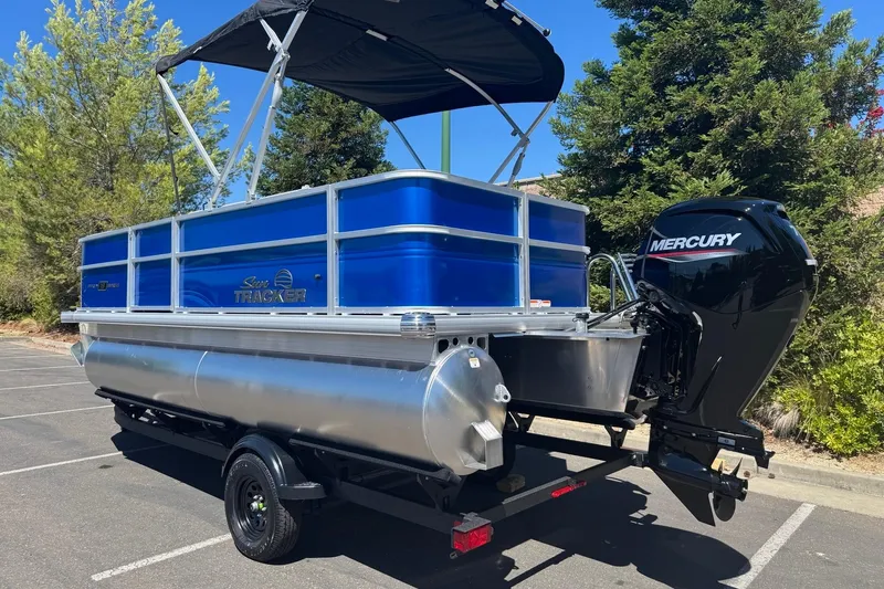 Slide: The Image of 2026 Sun Tracker Party Barge 18 DLX pontoon boat with Mercury engine in a parking lot. - 4