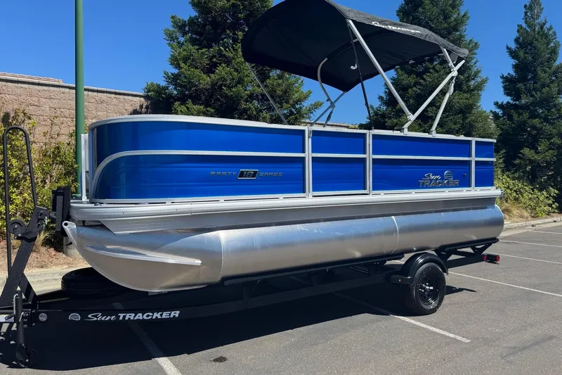 The Image of 2026 Sun Tracker Party Barge 18 DLX pontoon boat with blue exterior and canopy. - 0