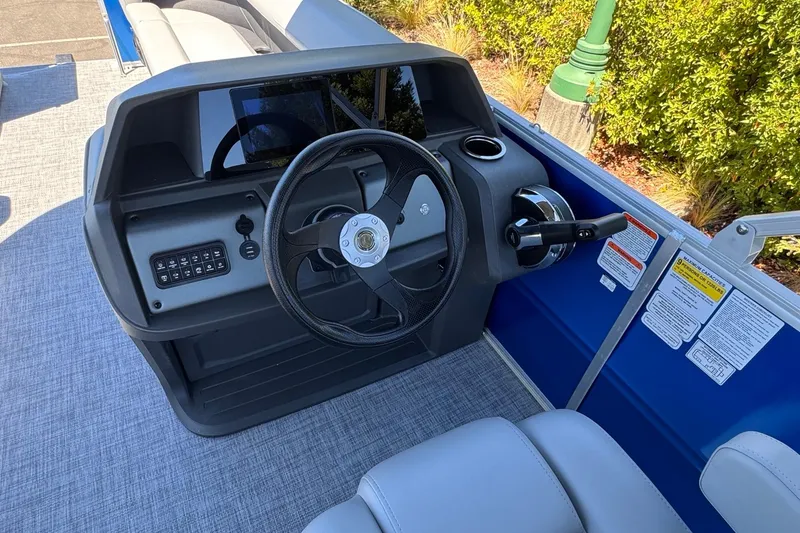 Slide: The Image of 2026 Sun Tracker Party Barge 18 DLX steering console with controls and seating. - 15