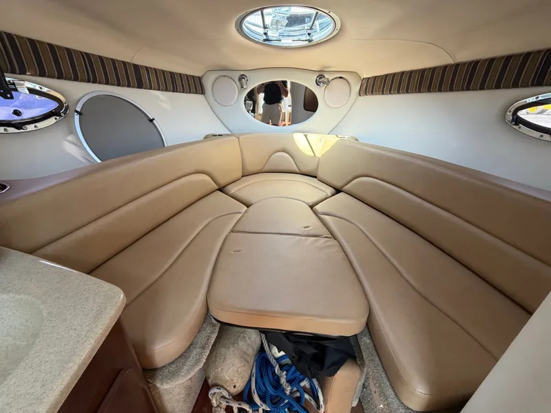 Slide: The Image of The image shows the interior of a 2018 Crownline 264 CR with beige upholstery and portholes. - 8
