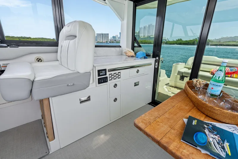 Slide: The Image of Interior of a 2022 Regal boat with seating, table, and scenic water view. - 10