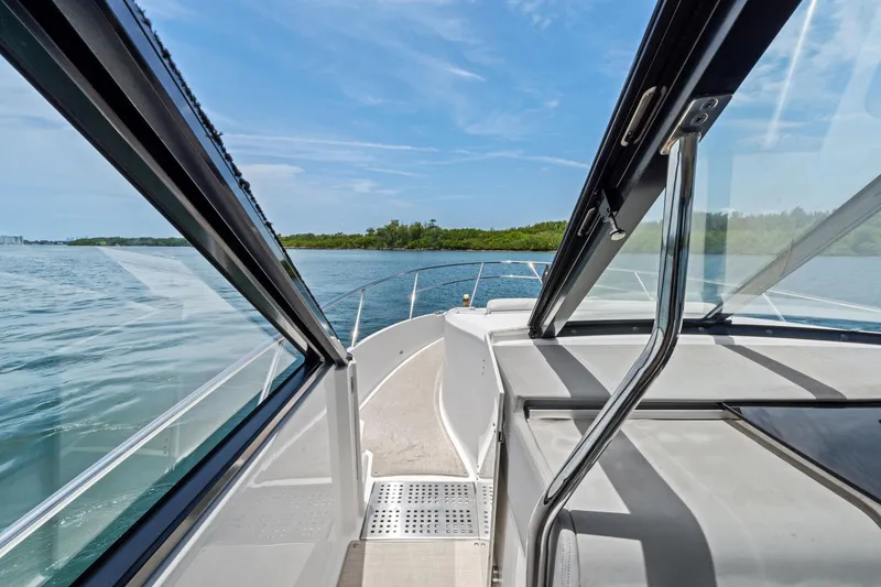 Slide: The Image of 2022 Regal boat cruising on a serene lake with clear blue skies. - 7