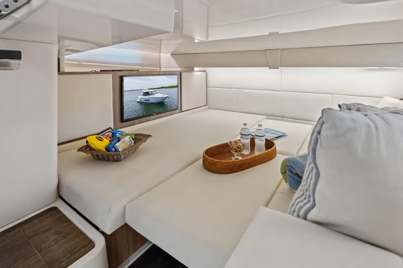 Slide: The Image of Luxurious 2022 Regal boat interior with cozy seating, snacks, and a TV displaying a boat. - 25