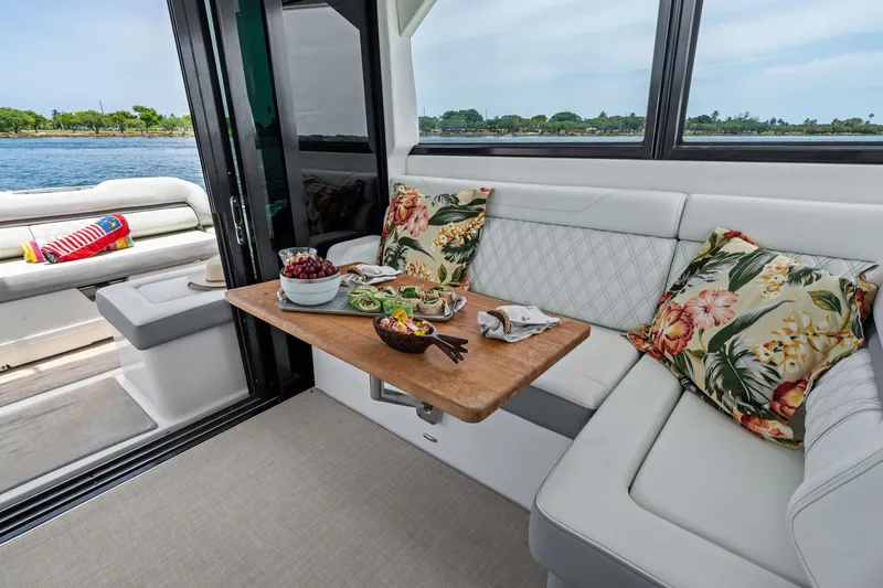 Slide: The Image of Luxurious 2022 Regal yacht interior with elegant seating, floral cushions, and a wooden dining table. - 12