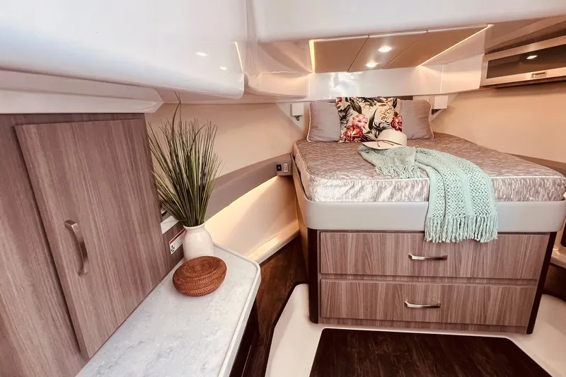 Slide: The Image of Luxurious 2022 Regal boat cabin with cozy bed, decorative pillows, and elegant wood cabinetry. - 29