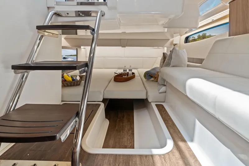 Slide: The Image of Luxurious 2022 Regal yacht interior with elegant white seating and modern wooden stairs. - 22