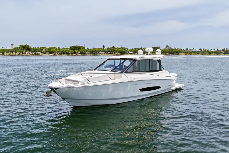 Slide: The Image of 2022 Regal boat on calm water near a lush shoreline. - 1