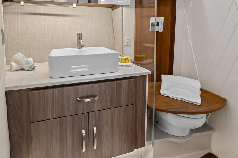 Slide: The Image of Modern 2022 Regal boat bathroom with sleek sink, wooden cabinetry, and compact toilet. - 27