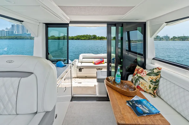 Slide: The Image of Luxurious 2022 Regal yacht interior with elegant seating, wooden table, and scenic water view. - 14