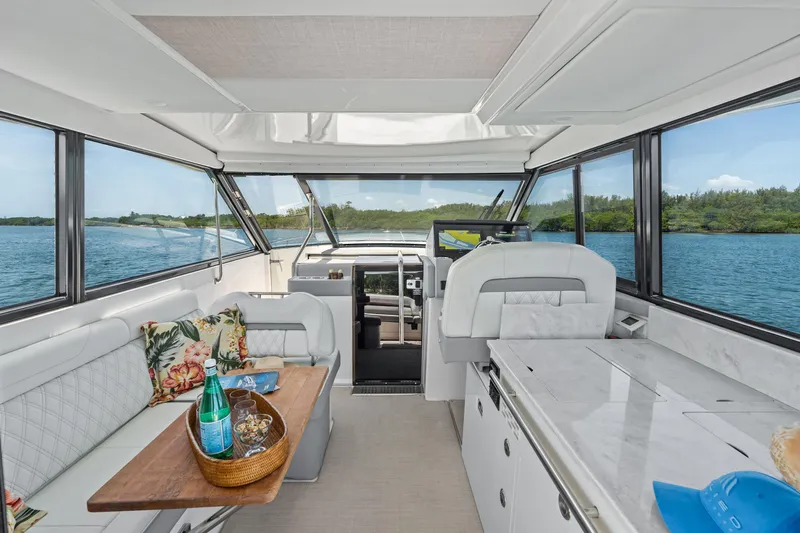Slide: The Image of Luxurious 2022 Regal boat interior with elegant seating, table, and scenic water views. - 13