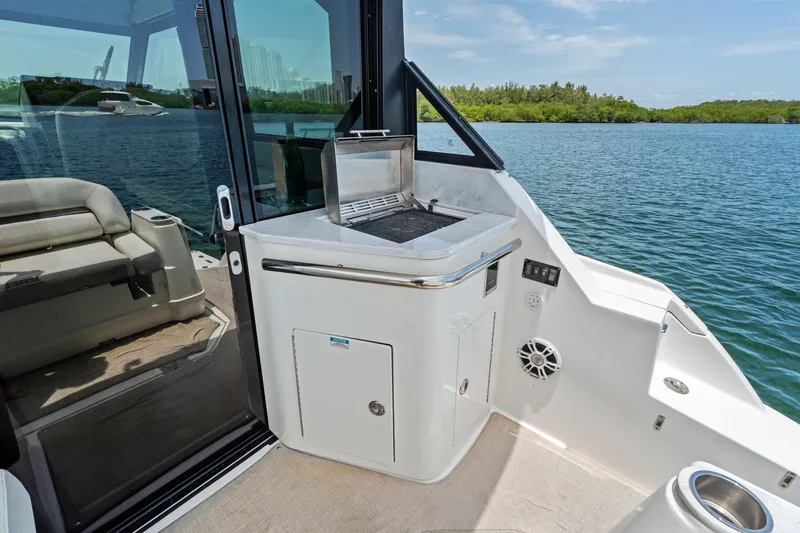 Slide: The Image of Luxury Regal boat interior with grill, seating, and scenic water view, 2022 model. - 21
