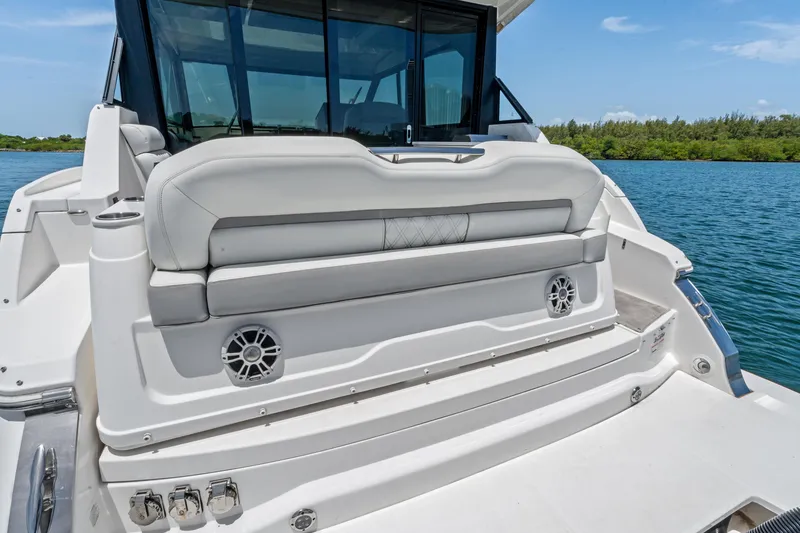 Slide: The Image of Luxury Regal boat rear seating area with speakers, 2022 model, on a serene water backdrop. - 33