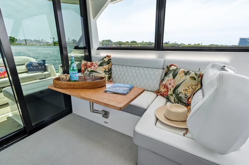 Slide: The Image of Luxurious 2022 Regal boat interior with floral cushions, wooden table, and scenic water view. - 15