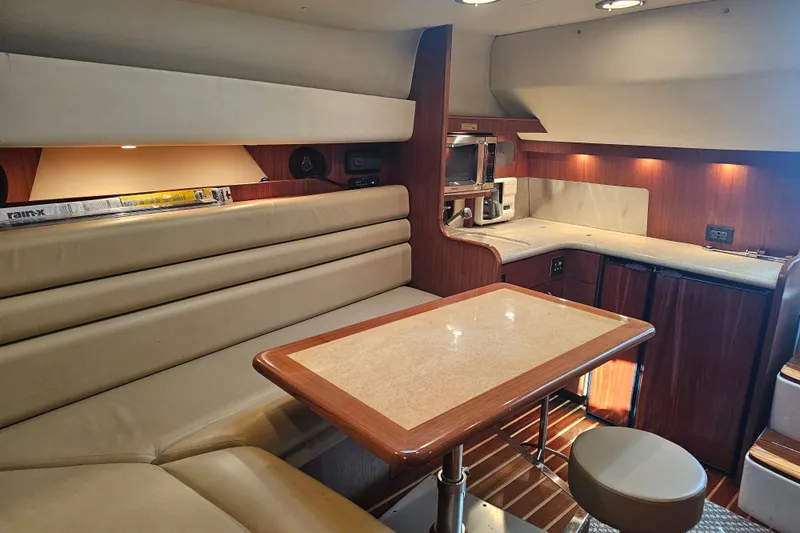 Slide: The Image of Luxurious interior of a 2003 Tiara Yachts 3800 Open, featuring elegant seating and a compact kitchen. - 8