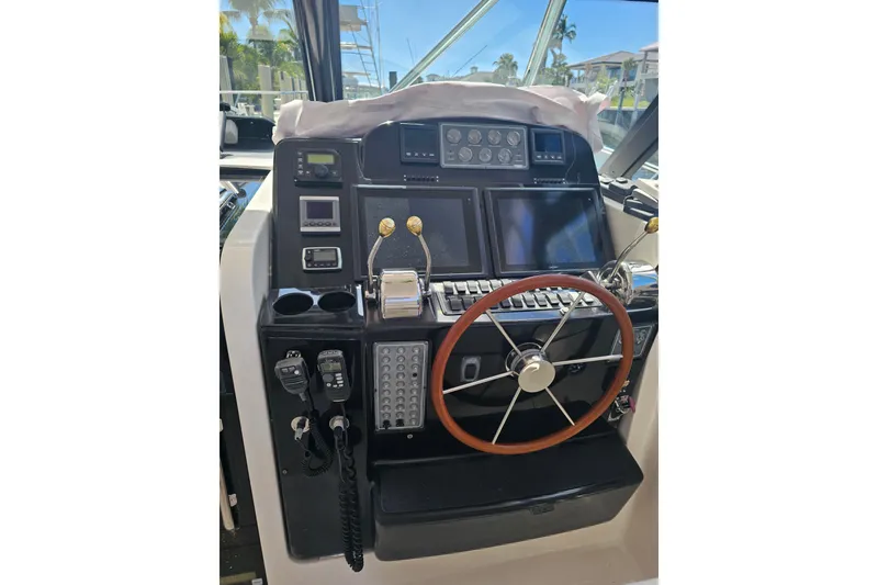 Slide: The Image of 2003 Tiara Yachts 3800 Open helm with navigation controls and wooden steering wheel. - 4