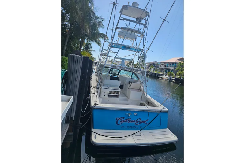 Slide: The Image of 2003 Tiara Yachts 3800 Open docked in a sunny marina setting. - 3