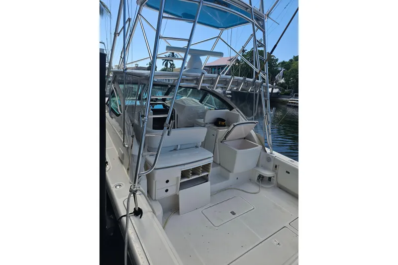Slide: The Image of 2003 Tiara Yachts 3800 Open boat interior with seating and storage, docked by water. - 5