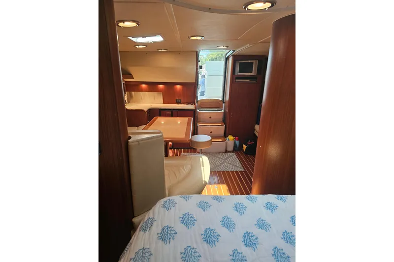 Slide: The Image of Interior of 2003 Tiara Yachts 3800 Open, featuring cozy seating and wooden finishes. - 11