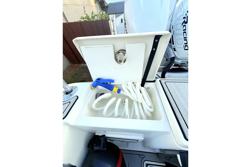 Slide: The Image of 2005 Hydra-Sports 3300 VX boat with open storage compartment and coiled hose. - 19