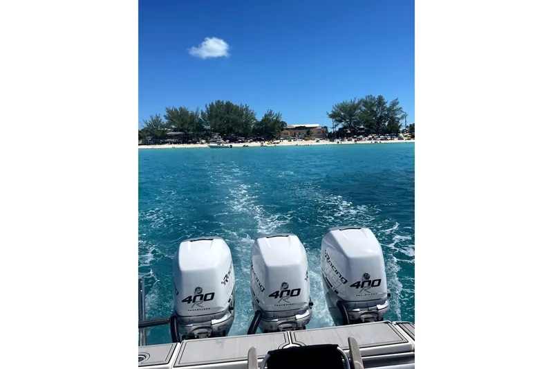 Slide: The Image of 2005 Hydra-Sports 3300 VX boat with triple engines cruising on clear blue water. - 20