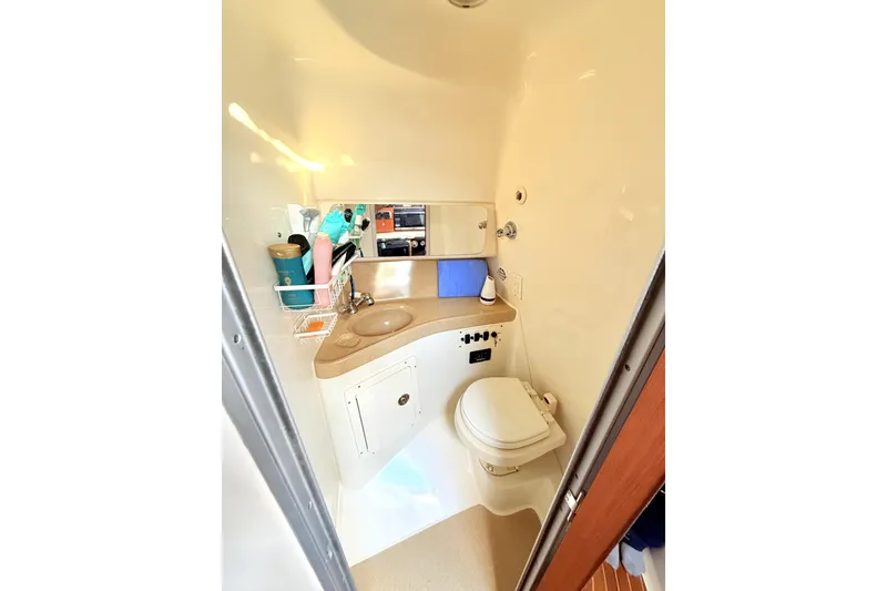 Slide: The Image of 2005 Hydra-Sports 3300 VX boat bathroom with sink, toilet, and storage shelves. - 12