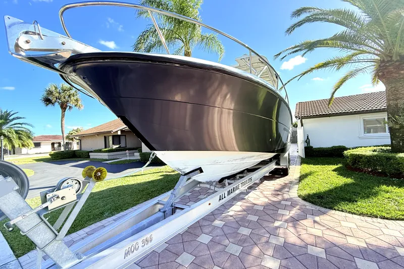 Slide: The Image of 2005 Hydra-Sports 3300 VX boat on trailer, parked in a sunny residential driveway. - 3