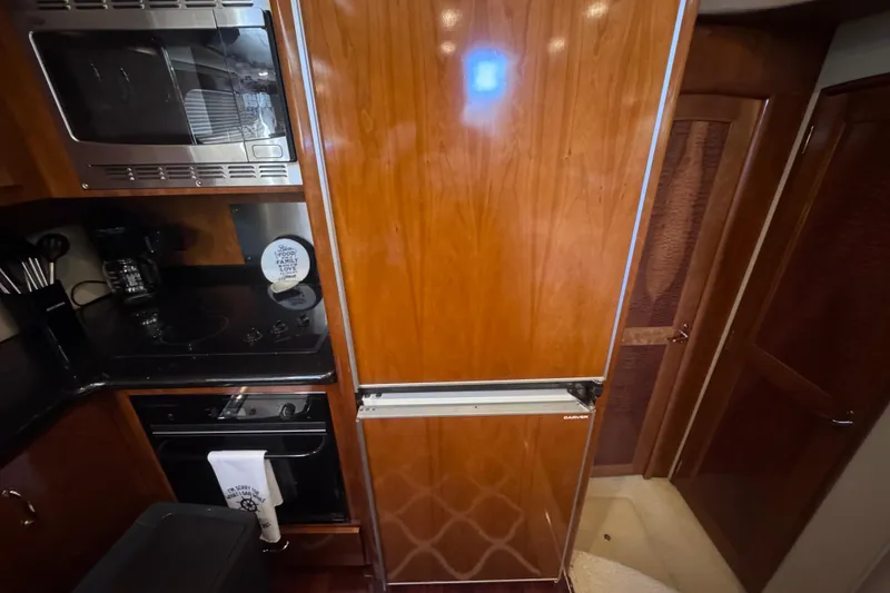 Slide: The Image of Luxurious kitchen area in a 2004 Carver 466 Motor Yacht with wooden cabinetry. - 31