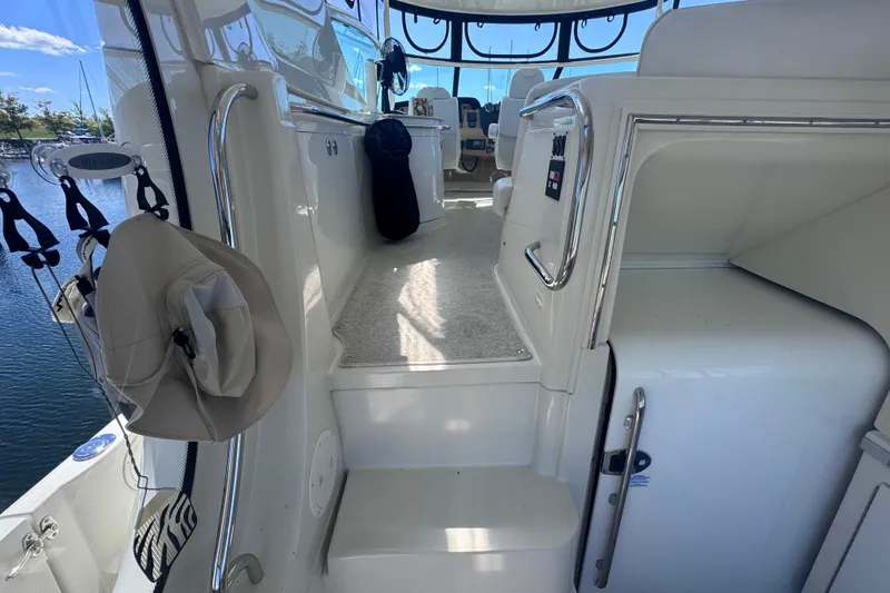 Slide: The Image of 2004 Carver 466 Motor Yacht interior with steps and seating area, docked by the water. - 5