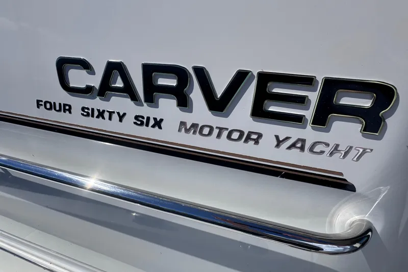 Slide: The Image of 2004 Carver 466 Motor Yacht logo on white surface with chrome accents. - 43