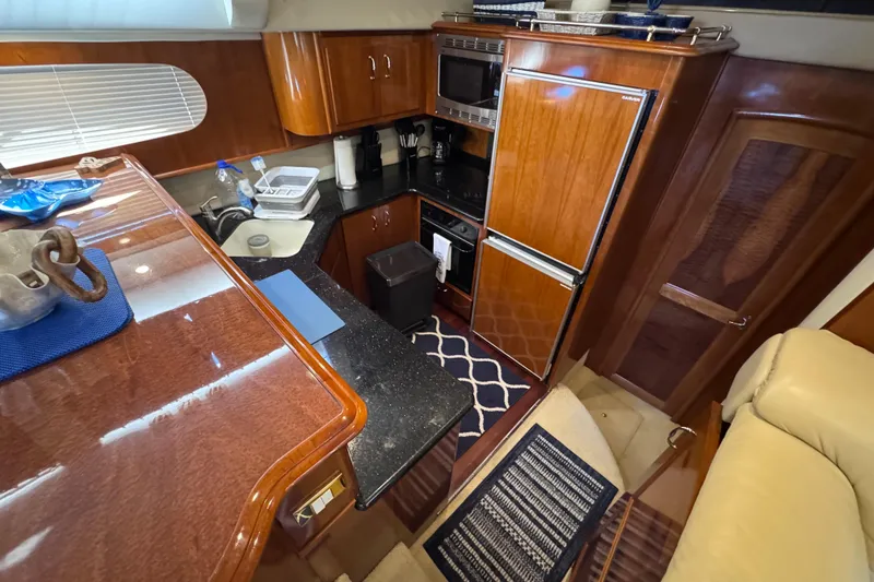 Slide: The Image of Luxurious kitchen interior of 2004 Carver 466 Motor Yacht with wood cabinetry and modern appliances. - 16