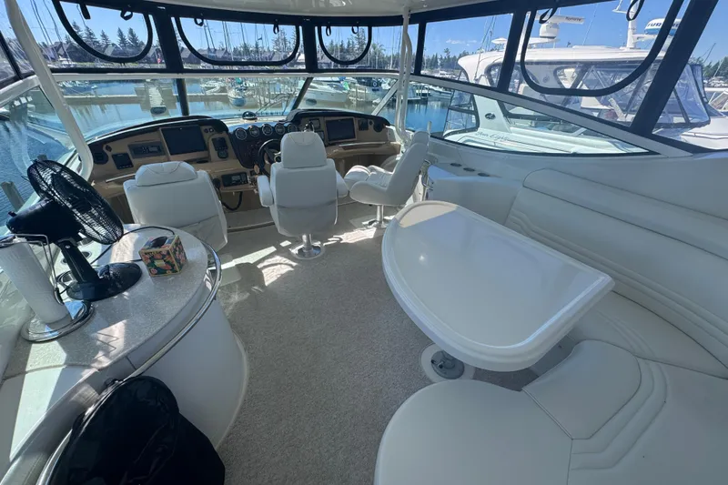 Slide: The Image of Interior of 2004 Carver 466 Motor Yacht with helm, seating, and marina view. - 6