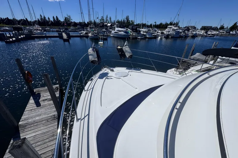Slide: The Image of 2004 Carver 466 Motor Yacht docked at a marina under clear blue skies. - 38