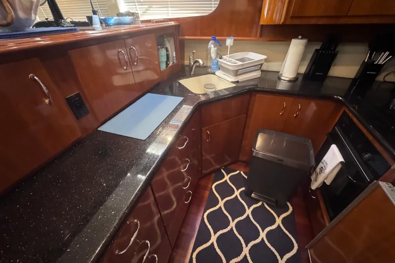 Slide: The Image of Luxurious kitchen interior of 2004 Carver 466 Motor Yacht with sleek countertops and wooden cabinetry. - 30
