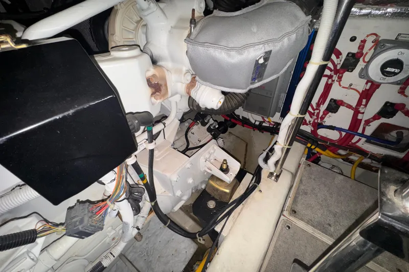 Slide: The Image of Engine room of a 2004 Carver 466 Motor Yacht, showcasing mechanical components and wiring. - 54