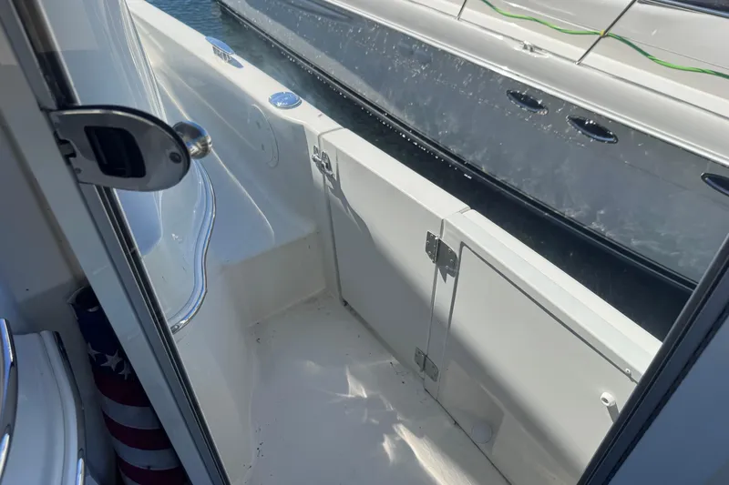 Slide: The Image of 2004 Carver 466 Motor Yacht deck area with open door, showcasing sleek design and water view. - 46