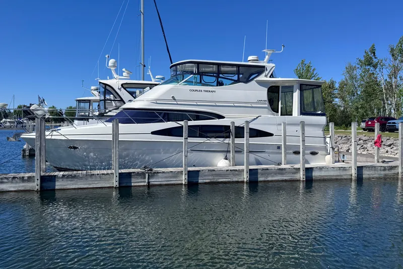Slide: The Image of 2004 Carver 466 Motor Yacht docked at a marina on a sunny day. - 0