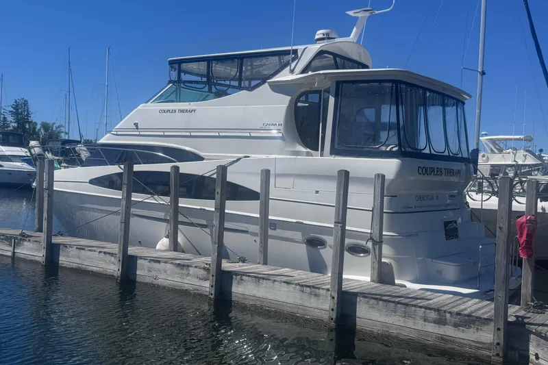 Slide: The Image of 2004 Carver 466 Motor Yacht docked at marina under clear blue sky. - 2
