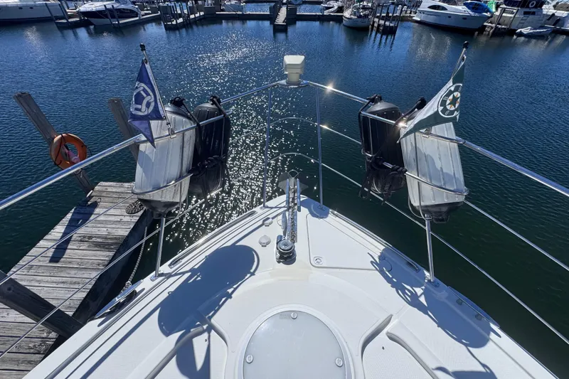 Slide: The Image of Bow view of 2004 Carver 466 Motor Yacht docked in a marina. - 39