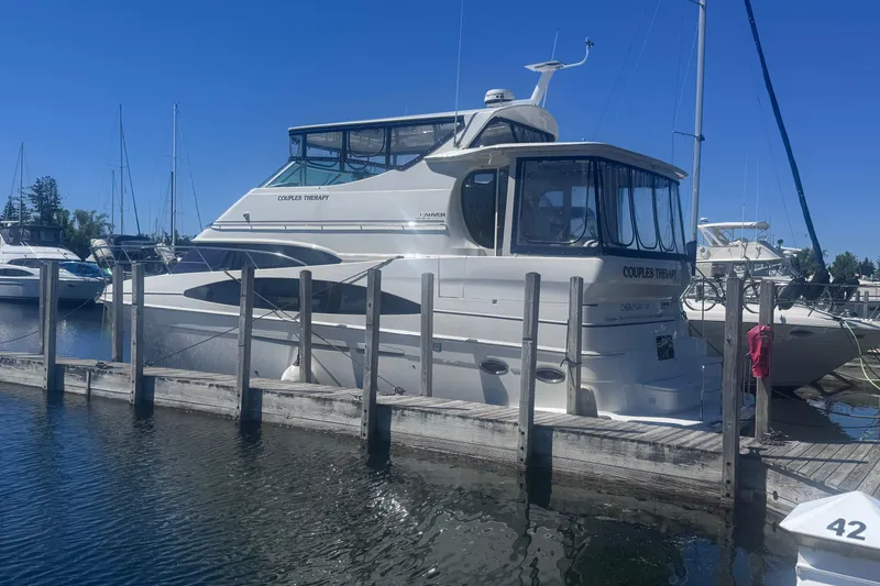 Slide: The Image of 2004 Carver 466 Motor Yacht docked at marina under clear blue sky. - 1
