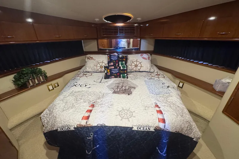 Slide: The Image of Luxurious bedroom in 2004 Carver 466 Motor Yacht with nautical-themed bedding. - 34