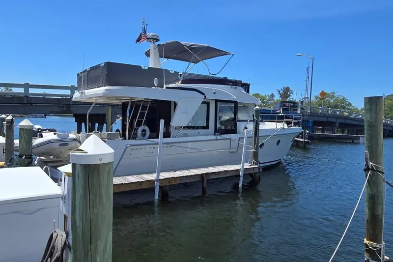 Slide: The Image of 2021 Beneteau Swift Trawler 41 Fly docked at marina under clear blue sky. - 19
