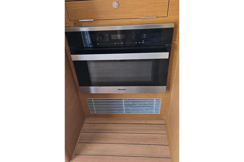 Slide: The Image of Built-in oven in 2021 Beneteau Swift Trawler 41 Fly, featuring sleek wood paneling. - 5