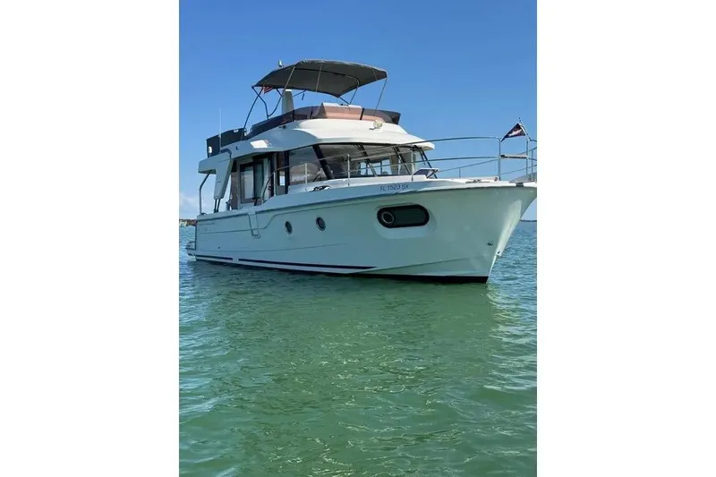 The Image of 2021 Beneteau Swift Trawler 41 Fly on calm water, showcasing sleek design and spacious flybridge. - 0