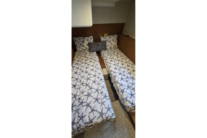 Slide: The Image of Twin beds with starfish-patterned bedding in 2021 Beneteau Swift Trawler 41 Fly cabin. - 15