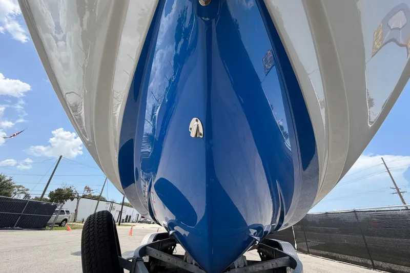 Slide: The Image of 2024 Yamaha Boats 222XD hull, blue and white, on trailer under clear sky. - 9