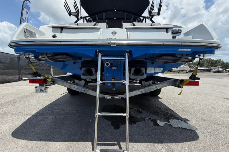 Slide: The Image of 2024 Yamaha Boats 222XD on trailer, rear view with ladder and dual engines. - 4