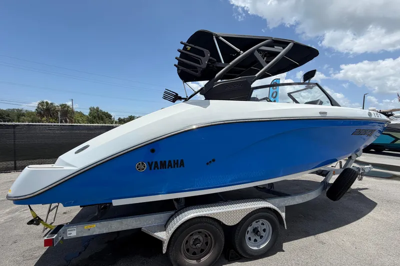 Slide: The Image of 2024 Yamaha Boats 222XD in blue on a trailer under a clear sky. - 2