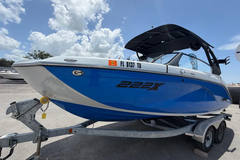 Slide: The Image of 2024 Yamaha Boats 222XD in blue on trailer under a cloudy sky. - 7