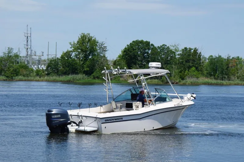 Slide: The Image of 1999 Grady-White Tournament 225 boat cruising on a scenic river. - 4